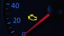 close up of speedometer with yellow check engine light