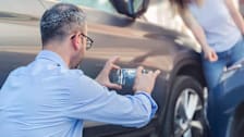 Person photographing a fender bender with their phone.