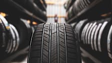 A tire up close in the middle of an aisle full of tires on both sides.