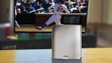 Asus ZenWiFi BT8 wireless router with a Mets game in the background.