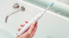 detail of person holding Philips Sonicare DiamondClean Smart 9300 Toothbrush over bathroom sink