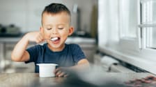 a young boy eating yogurt
