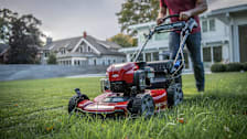 a person mowing a residential lawn with a Toro Personal Pace Recycler 21465 Gas Self-Propelled Mower