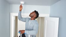 a person using a First Alert SMI100 smoke detector