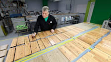A Consumer Reports technician inspecting wood floor samples after testing with hardwood floor cleaners.