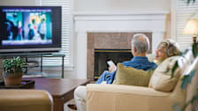 A couple sitting on the couch enjoying a TV show