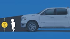 This image illustrates a child in a truck's blind spot, emphasizing the "out of view" area in front of a pickup.