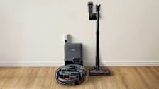 Eufy 3-in-1 vacuum with accessories on wood floor against white wall