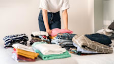 Woman sorting clothes on her bed