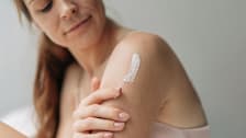 Woman applying lotion to her arm