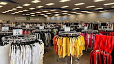 Racks of colorful clothing inside of a Goodwill store.