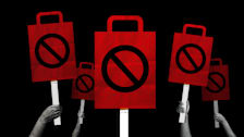 Photo illustration of multiple hands holding up protest signs in the shape of shopping bags.