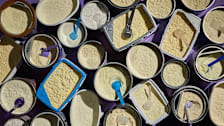 Numerous open containers of infant formula photographed from above.