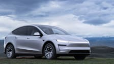 2027 Tesla Model Y L parked at a scenic location overlooking rolling hills