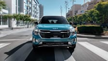 Kia Seltos driving on an urban street.