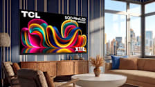 TCL SQD-Mini LED QLED Mini-LED X11L TV on wall in high rise apartment living room with city view from windows