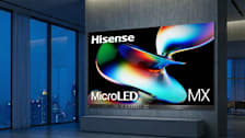 Hisense 163 MX MicroLED TV in high rise apartment living room with concrete wall and view of city in background