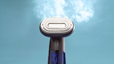 Conair ExtremeSteam 2-in-1 clothes steamer with cloud of steam coming out of it
