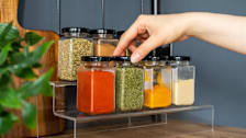 Hand reaching for spices on a spice shelf