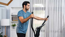 A man using an elliptical at home.