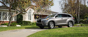 grey 2015 Toyota Highlander in driveway in front of a house