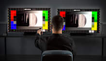 CR tech testing two televisions.