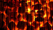 Red hot coals underneath a grill
