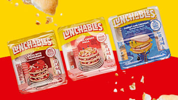 three different varieties of Lunchables (Pizza with Pepperoni, Extra Cheesy Pizza, and Turkey and Cheddar) with breadcrumbs in background