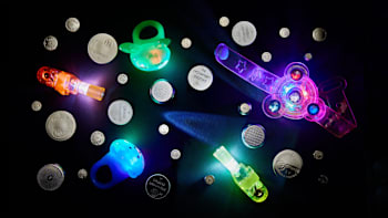 overhead view of various sizes of button batteries with light up toys