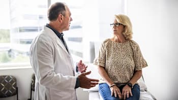 Doctor consulting with patient in exam room.