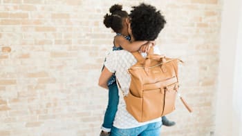 Woman holding child wearing Lily Jade diaper bag
