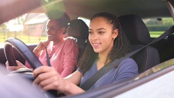 Teen and her mother in the car on a sunny day.