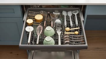 third rack of dishwasher filled with utensils