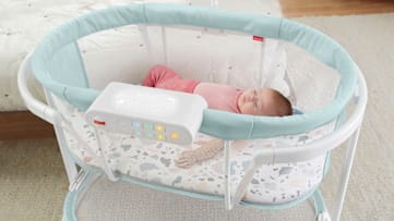 A baby sleeping in a bassinet.