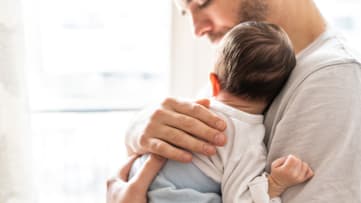 A dad holding his newborn baby