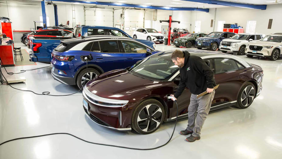 CR tech placing an electric plug into an EV vehicle at the CR garage.