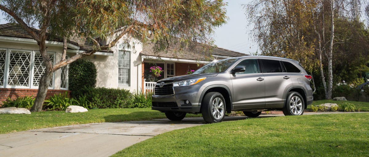 grey 2015 Toyota Highlander in driveway in front of a house