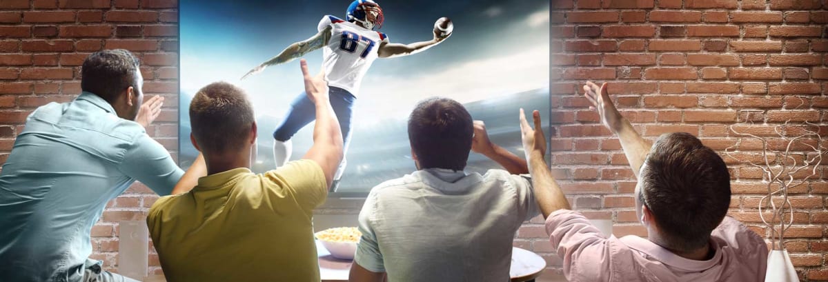 men cheering as they watch american football