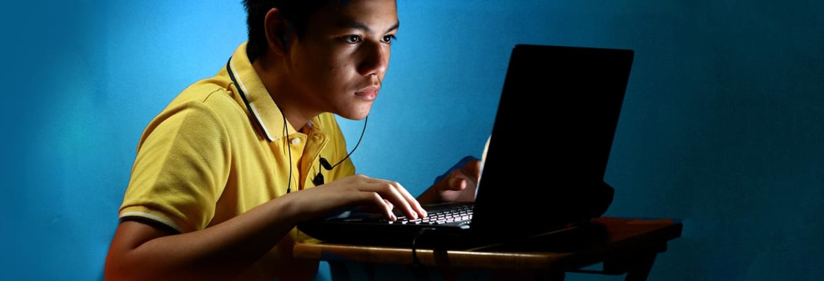 Boy playing on a laptop