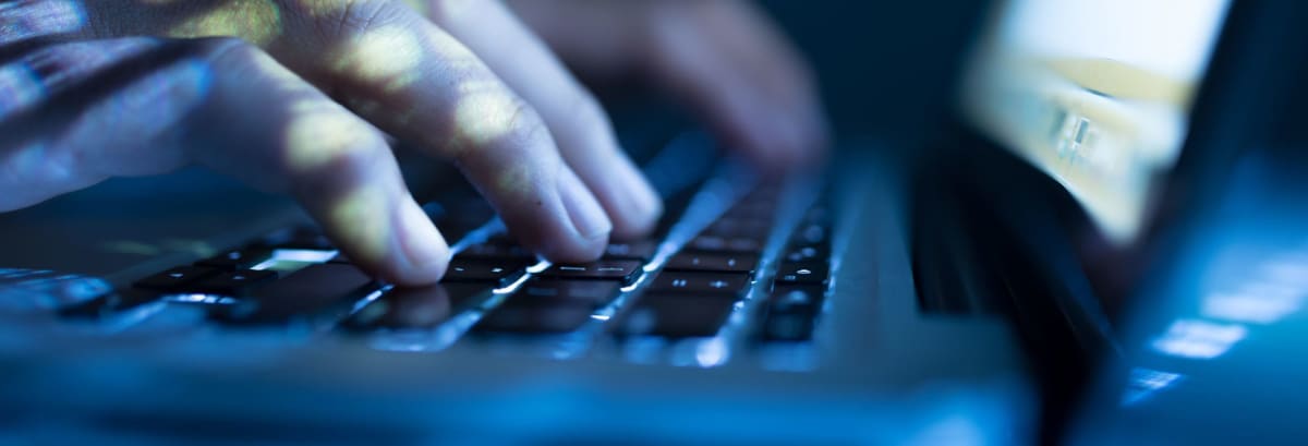 Hacker typing on computer keyboard