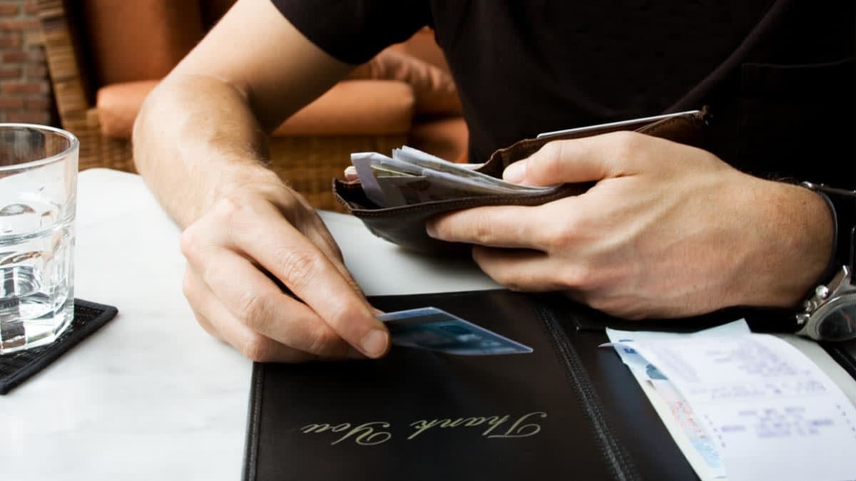 man paying for restaurant bill with credit card