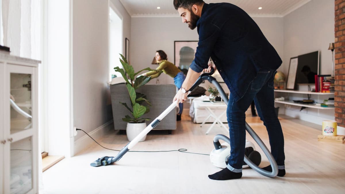 Man vacuuming in house