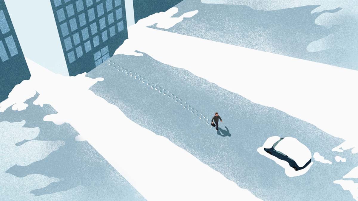 High angle view of man walking on snow covered road in city