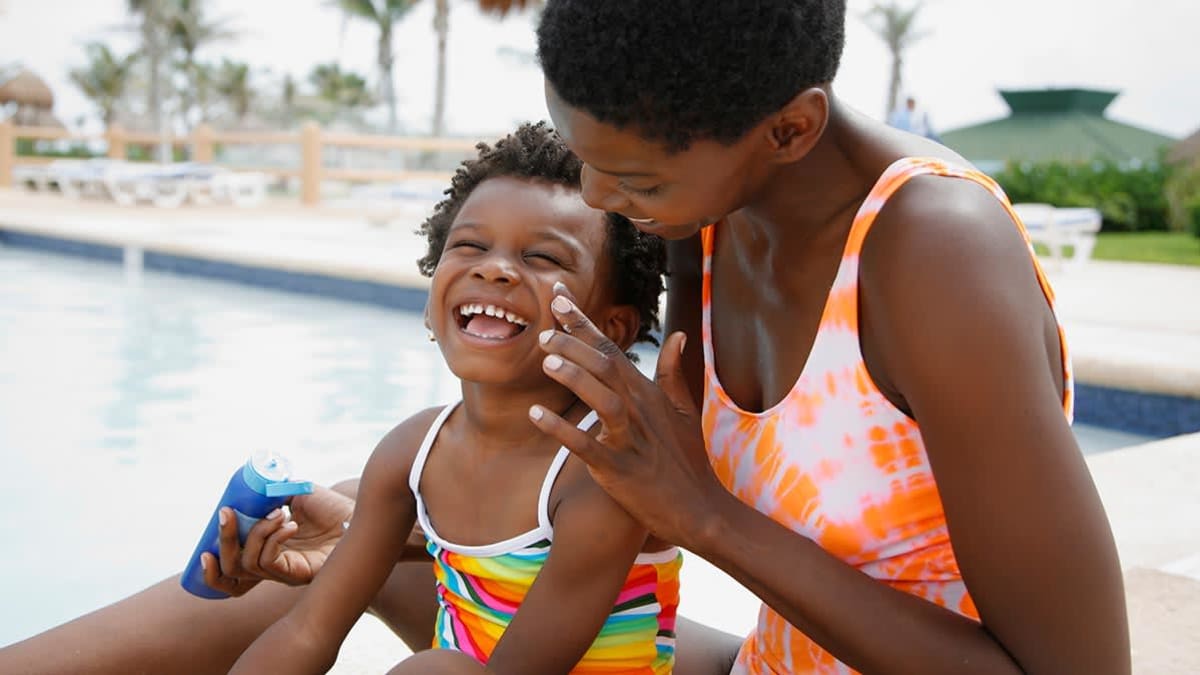Mother putting sunscreen on child