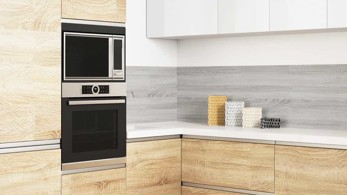 view of corner of kitchen with wall oven and microwave and 4 containers on counter