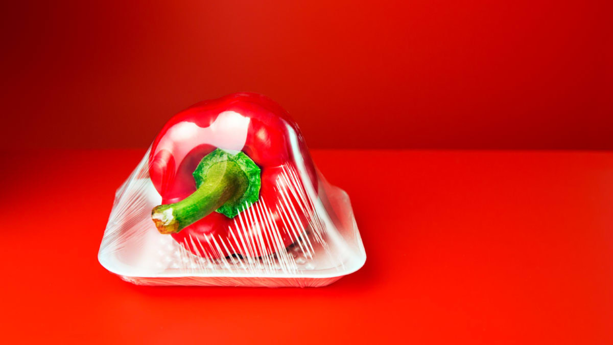 plastic covered red pepper on red background