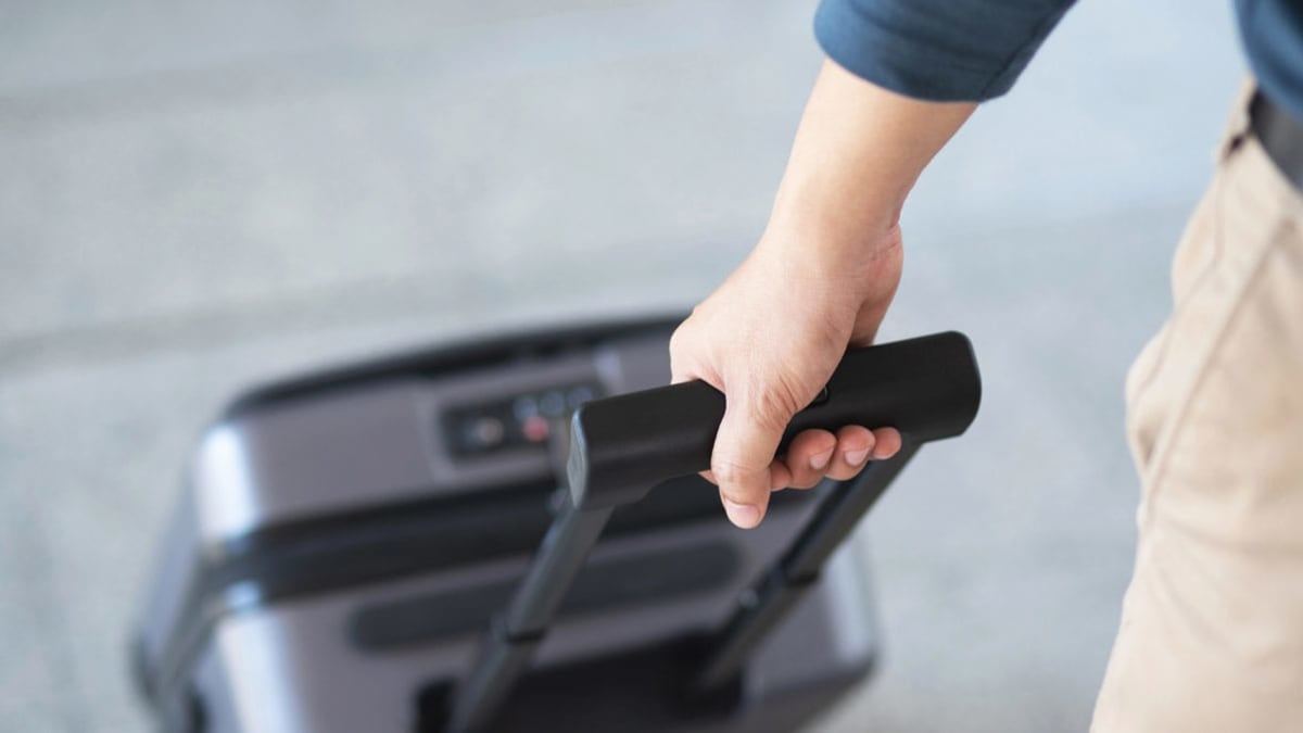 man pulling his carry on luggage