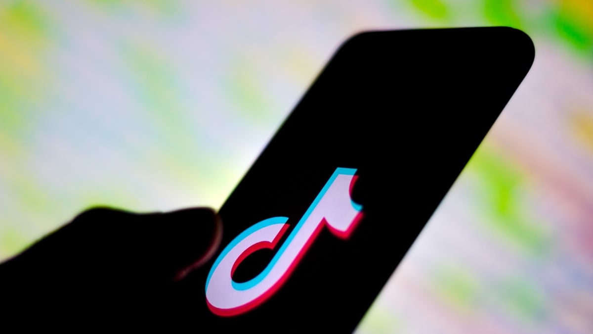 hand with phone with TikTok logo