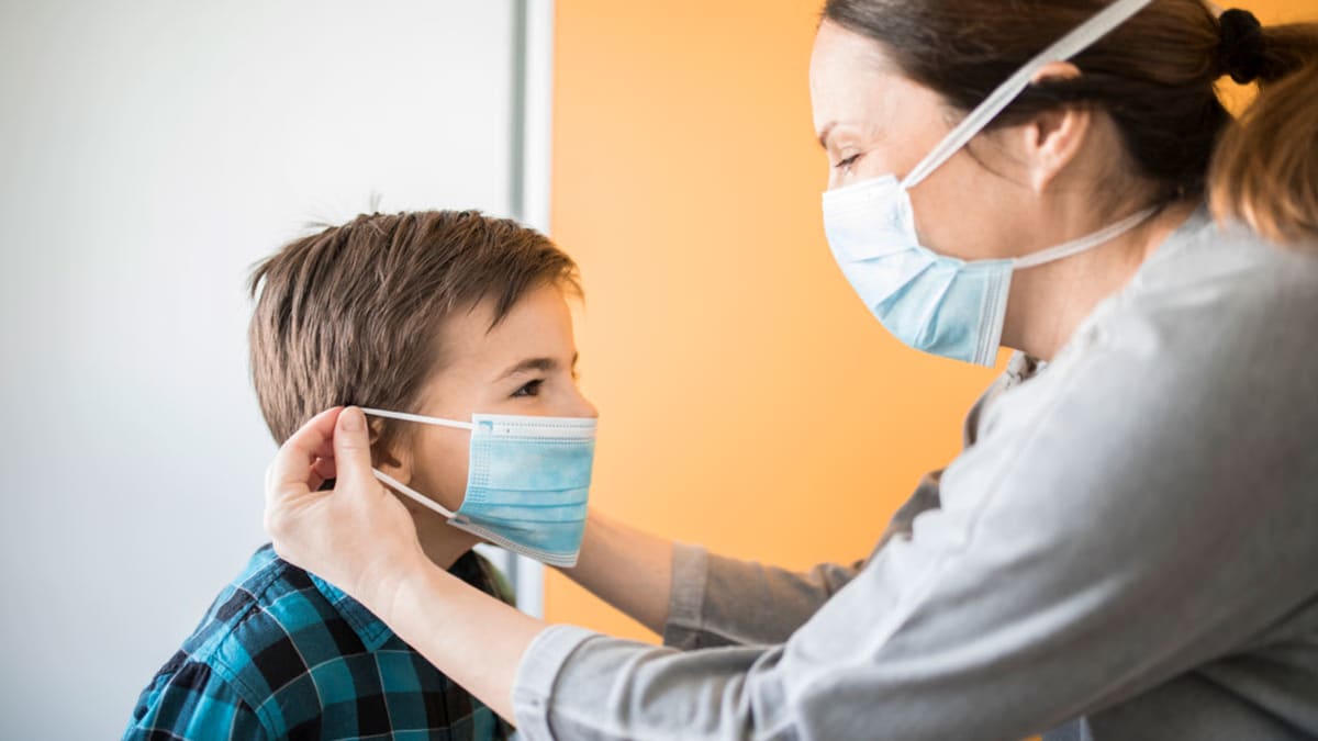 mother putting mask on child