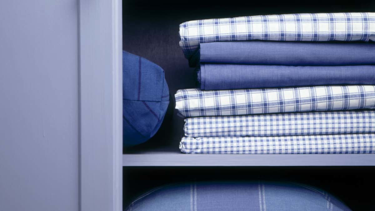 detail of stack of various blue linens in closet
